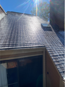 Expert roof washing company cleaning shingles to restore roof appearance and longevity