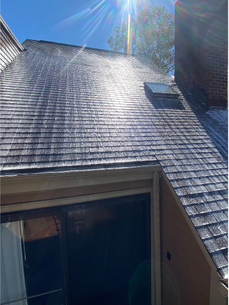 Roof being gently roof washed by AnA Home Services, removing moss and stains for a renewed appearance