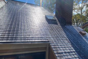 Roof being gently roof washed by AnA Home Services, removing moss and stains for a renewed appearance